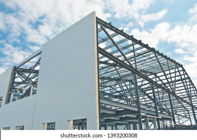 Metal frame of the building with a sandwich panel of insulation on the wall. Construction of a new industrial building.