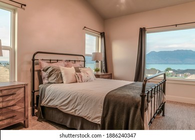 Metal frame double bed inside bedroom with view of the lake and neighborhood