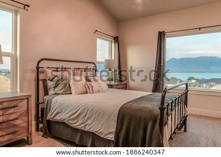 Metal frame double bed inside bedroom with view of the lake and neighborhood