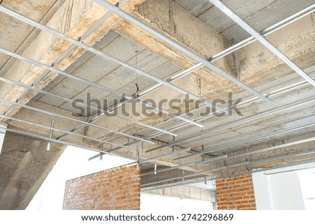 The metal framework for the suspended ceiling is currently being installed.
The C-line main runners and cross tees are neatly aligned to create a sturdy base for the ceiling.