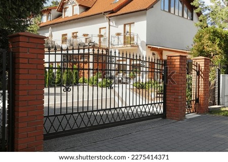 Metal gates near beautiful estate on sunny day