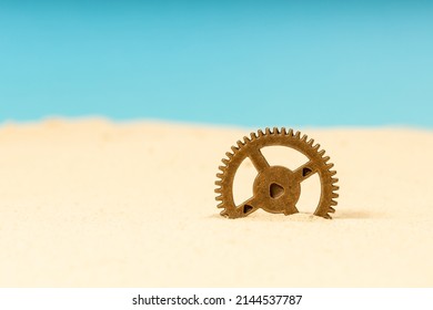 A Metal Gear, Brass In The Sand, A Gear Sticking Out Of The Sand. Lost Civilization.