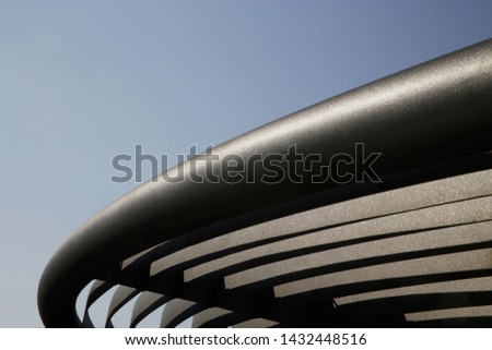 Metal girders. Curved detail of industrial building. Steel lath structure. Abstract modern architecture. Anti-corrosion protective powder coating. Geometric background with parallel lines and curves.