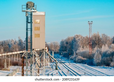Metal grain elevator next to railroad during winter season. Grain silo, warehouse or depository is an important part of harvesting.
