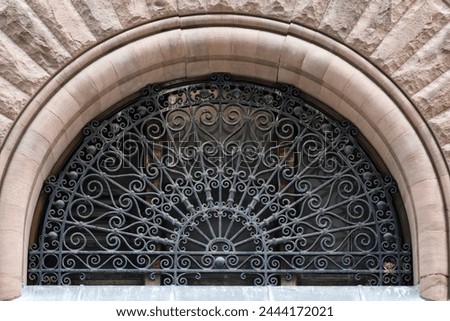 Metal grate in a door arch. Colonial architectural feature or detail in Old City Hall Building (1898), Toronto, Canada