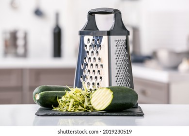 Metal grater and zucchini on kitchen table