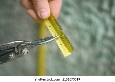 Metal Guides For Leveling The Wall With Concrete Mortar, Installation And Fastening Of Metal Guides, The Master Cuts The Guide Beacon With Scissors.