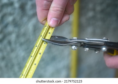 Metal Guides For Leveling The Wall With Concrete Mortar, Installation And Fastening Of Metal Guides, The Master Cuts The Guide Beacon With Scissors.