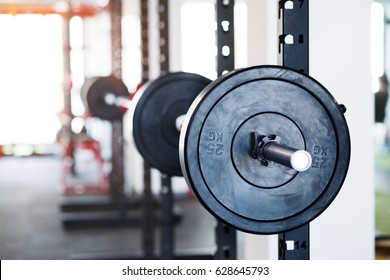 Metal Heavy Barbell In Holder In Modern Gym.