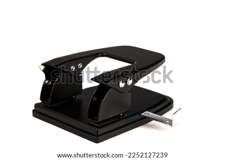 Metal hole punch. For making holes for paper.Manufacturer of red confetti. A hole punch machine. Sprinkle with paper punch. For office stitching. black. Close-up. place for text