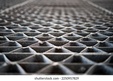 Metal industry steel grade sheet or floor grating with multicolored drops of paint macro closeup. Shallow depth of field diminished perspective industrial grates profiled drainage latticed flooring.