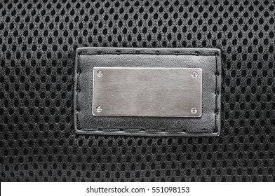 Metal Label On Old Black Leather Background