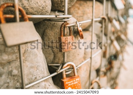 Metal locks on a grid with stones. Customs and traditions of lovers and newlyweds.Locks of lovers and newlyweds on the embankment.Love and fidelity symbol.