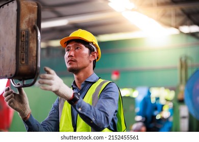Metal machine in heavy Industry Manufacturing. Asian male factory worker wearing safety hard hat helmet control lathe machine to drill components. - Powered by Shutterstock