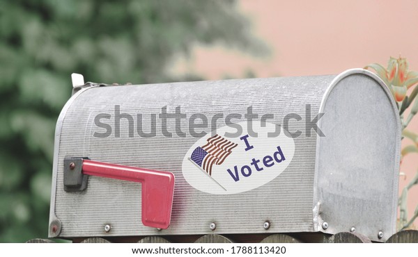 Metal mailbox for rural\
homes with I Voted sticker as concept for voting by mail or\
absentee ballot paper