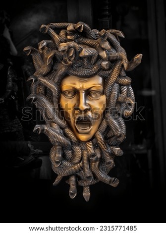 Metal mask of the Medusa Gorgon with framing snakes around the face, horrible creature from Greek mythology in european antique culture. Head of Medusa at a street souvenir market in Rhodes, Greece.