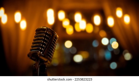 Metal microphone on blurred background with bokeh lights, close-up. Karaoke club. Wide Wallpaper or Web banner with copy space for design
