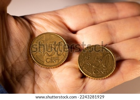 Metal money 50 euros, cents are counted on the hand, white background.
