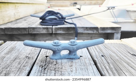 a metal nautical cleat on the dock, Yacht handle. Yacht detail. Boat cleat,Tight knot on a steel cleat of a boat, detail of tied nautical rope