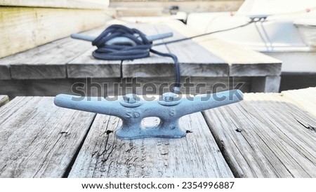 a metal nautical cleat on the dock, Yacht handle. Yacht detail. Boat cleat,Tight knot on a steel cleat of a boat, detail of tied nautical rope
