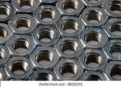 Metal nuts in an organized array pattern - Powered by Shutterstock