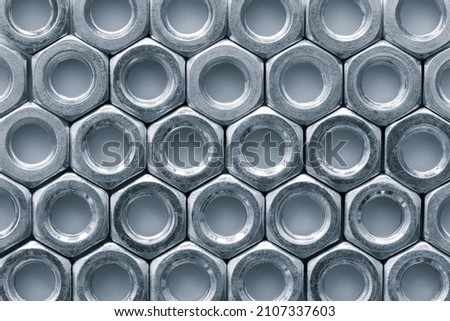 Metal nuts in a row background. Chromed screw nuts. Steel nuts pattern. Tools for work.