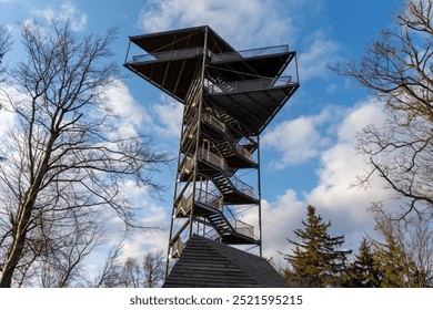 Metal observation tower on a clear winter day with bare trees and blue sky in the background. Scenic views, outdoor exploration and nature observation. High quality photo - Powered by Shutterstock