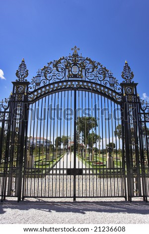 The metal openwork gate decorated by an emblem and a cross