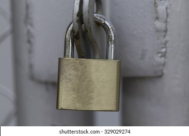 Metal Padlock Hanging On Rusty Gate