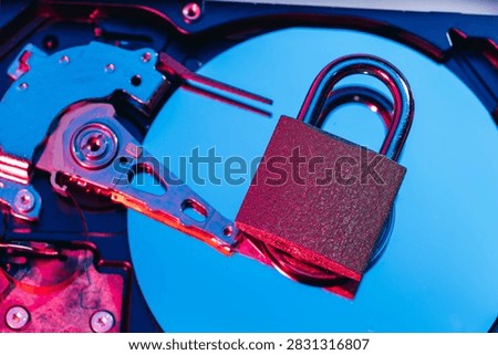 a metal padlock locking computer hard disk drive HDD components as a conceptual metaphor for cyber security data encryption privacy ransomware attack cloud storage defense and network safety