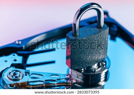 a metal padlock locking computer hard disk drive HDD components as a conceptual metaphor for cyber security data encryption privacy ransomware attack cloud storage defense and network safety