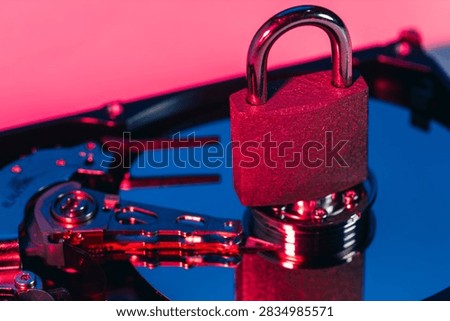a metal padlock locking computer hard disk drive HDD components as a conceptual metaphor for cyber security data encryption privacy ransomware attack cloud storage defense and network safety