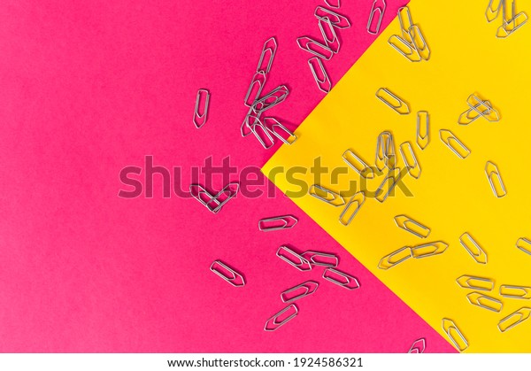 Metal paper clips on colorful\
backgrounds. The paper clips are divided into groups. Flat\
lay.
