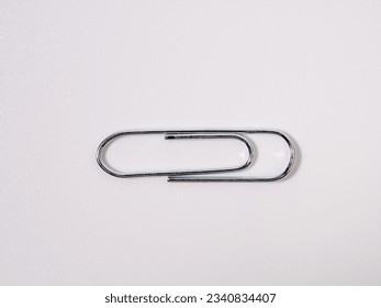 Metal paper clips on a white background. Paper clips close up