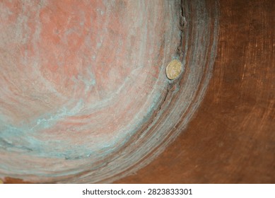 Metal Patch. Concave Handcrafted Copper Surface. Rings of Patina. Wear and Natural Oxidation. Shallow Depth of Field. Copy Space.