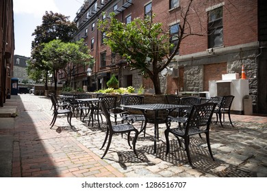 Metal Patio Furniture In The Courtyard Of An Urban Brick Apartment Building