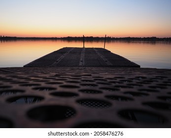 Metal pier with round holes. Evening or sunrise on a lake or river. Calm landscape. Rusting of metal structures. A pier for small cobbles and boats. Palic, Serbia. Travel, tourism and fishing - Shutterstock ID 2058476276