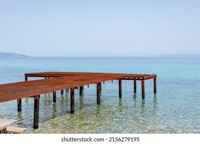 Metal pier and sea view. Rusty skeleton of an old pier and turquoise sea. Unfinished berth in clear water. Sea transport concept