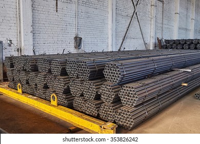 Metal pipes in a warehouse. Stacks of new round steel pipe in factory. 