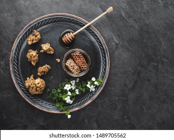 Metal Plate With Jar Of Honey, Pieces Of Propolis And Flowers On Gray Table. Overhead View.