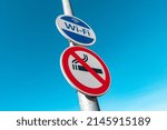 Metal pole with signs of Smoke-Free zone and Wireless Internet Hotspot