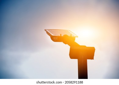 Metal pole of streetlamp which has mini solar cell panel above, sunset background. sustainable energy in daily life concept. Soft and selective focus.