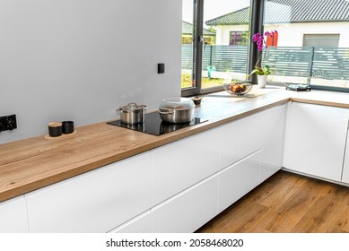 Metal Pots On An Induction Cooker Built Into The Kitchen Worktop, On The Cabinets.