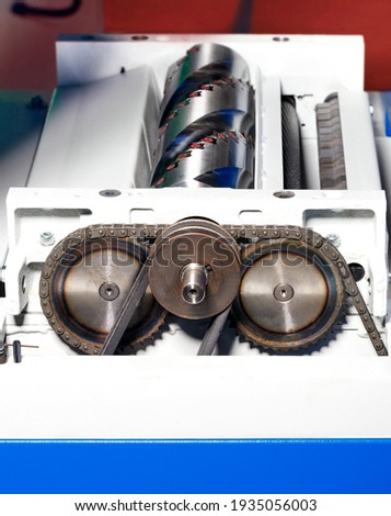 Metal pulleys, belt and chain drive on planer shaft of thicknesser, close-up, copy space.