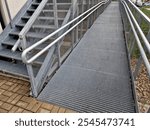 metal railings and metal grid on the floor. instead of stairs, there is a ramp for wheelchair users, a net, galvanized material. wheelchair lift. residential building, hospital entrance, senior, 