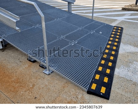 metal railings and metal grid on the floor. instead of stairs, there is a ramp for wheelchair users, a net, galvanized material. wheelchair lift. residential building, hospital entrance, senior, 