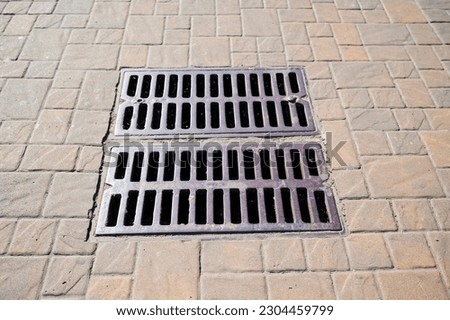 metal rain drain on the street, sewer grate in the asphalt