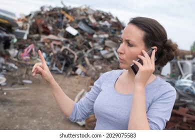 metal recycling worker gesturing and using mobile phone at junkyard - Powered by Shutterstock