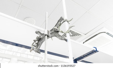 Metal Retort Stand Or Retort Clamp With Burette In Empty Lab. Concept Of Laboratory Equipment Or Analytical Chemistry. Slightly De-focused And Close-up Shot. Copy Space.