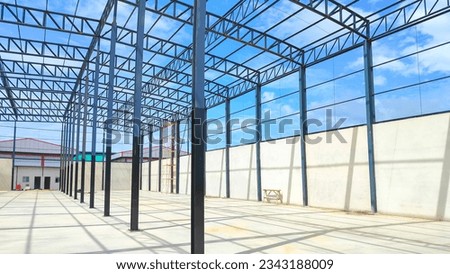 Metal roof beam and columns outline of new industrial building structure in construction site area against blue sky in perspective side view